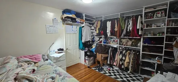 a view of walk in closet with clothes and shoes