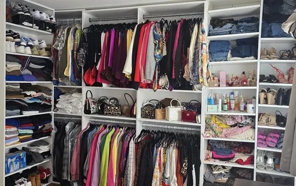 a view of walk in closet with clothes and shoes
