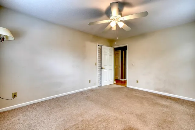 a view of an empty room with a chandelier fan