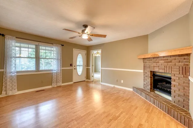 a view of an empty room with a fireplace and a window