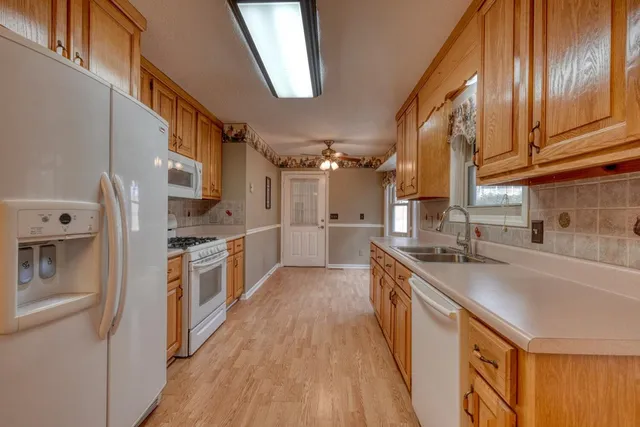 a large kitchen with stainless steel appliances granite countertop a lot of counter space and wooden floor