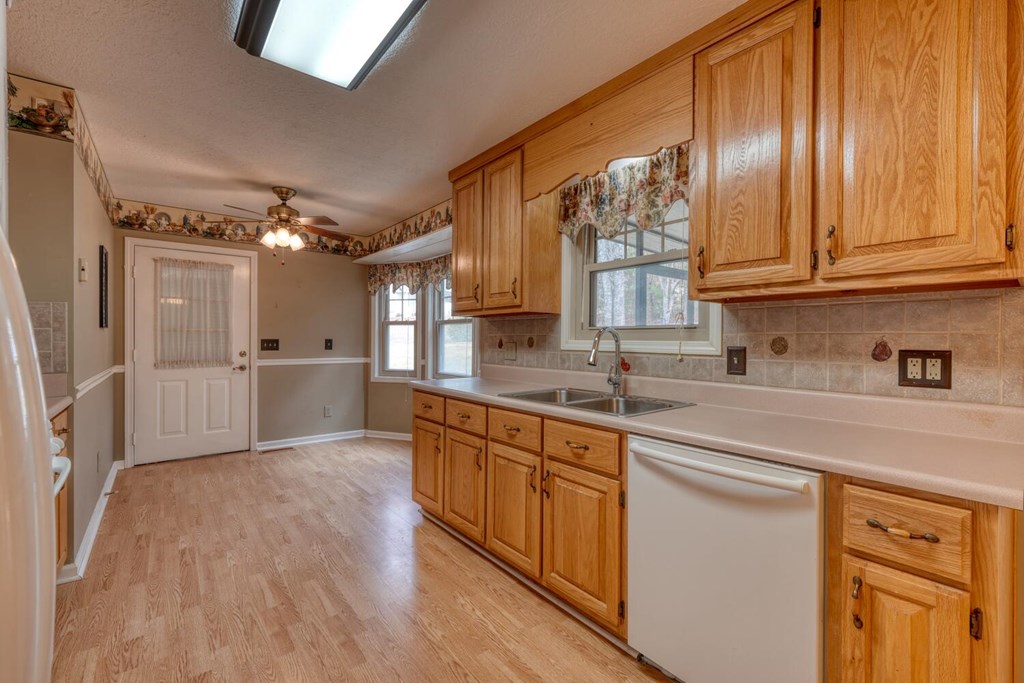 241 12 Point Road Blairsville, GA 30512 - Photo 10 of 34 a kitchen with granite countertop wooden cabinets stainless steel appliances a sink and a window
