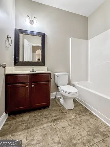 a bathroom with a tub sink and mirror