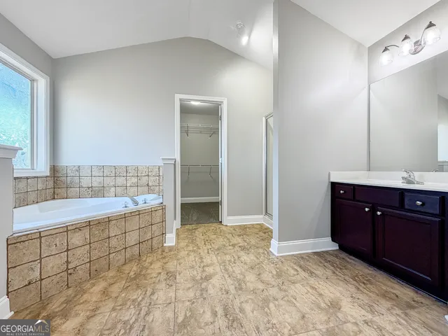 an empty room with windows and ceiling fan