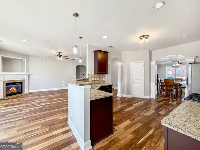 a view of a livingroom with wooden floor and a fireplace