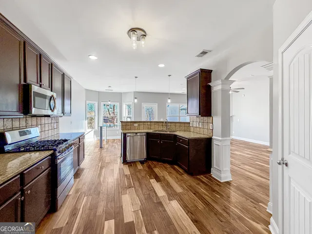 a kitchen with stainless steel appliances kitchen island granite countertop a refrigerator stove and oven