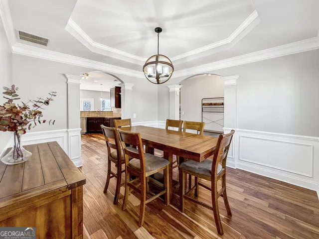 a view of a dining room with furniture wooden floor and chandelier
