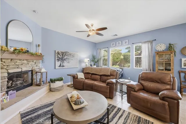 a living room with furniture a fireplace and a large window