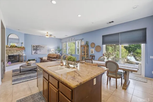 a kitchen with a stove a sink dishwasher and a dining table with garden view
