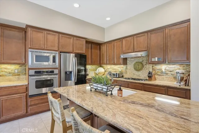 a kitchen with granite countertop a refrigerator stove and microwave