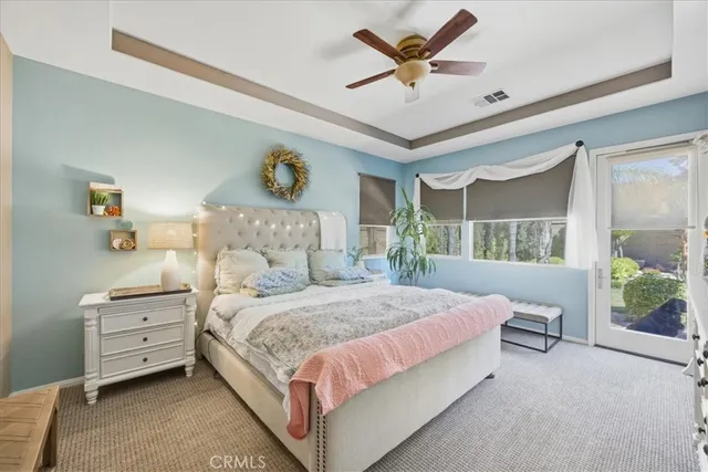 a bedroom with a bed a window and a chandelier