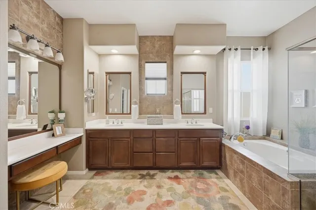 a large bathroom with a double vanity sink a large mirror and a bathtub