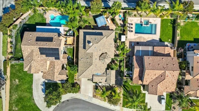 an aerial view of a house with a yard and large tree