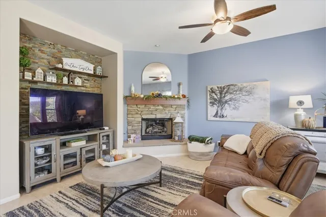 a living room with furniture a fireplace and a flat screen tv
