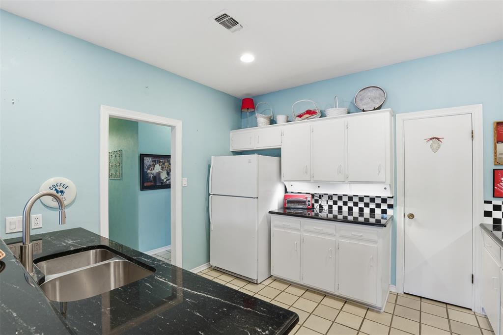 3800 Hollow Creek Road Benbrook, TX 76116 - Photo 13 of 29 a kitchen with refrigerator and white cabinets