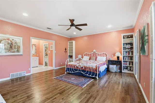 a spacious bedroom with a bed and wooden floor