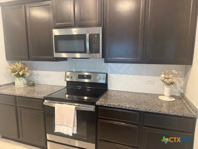 a kitchen with granite countertop a sink and cabinets