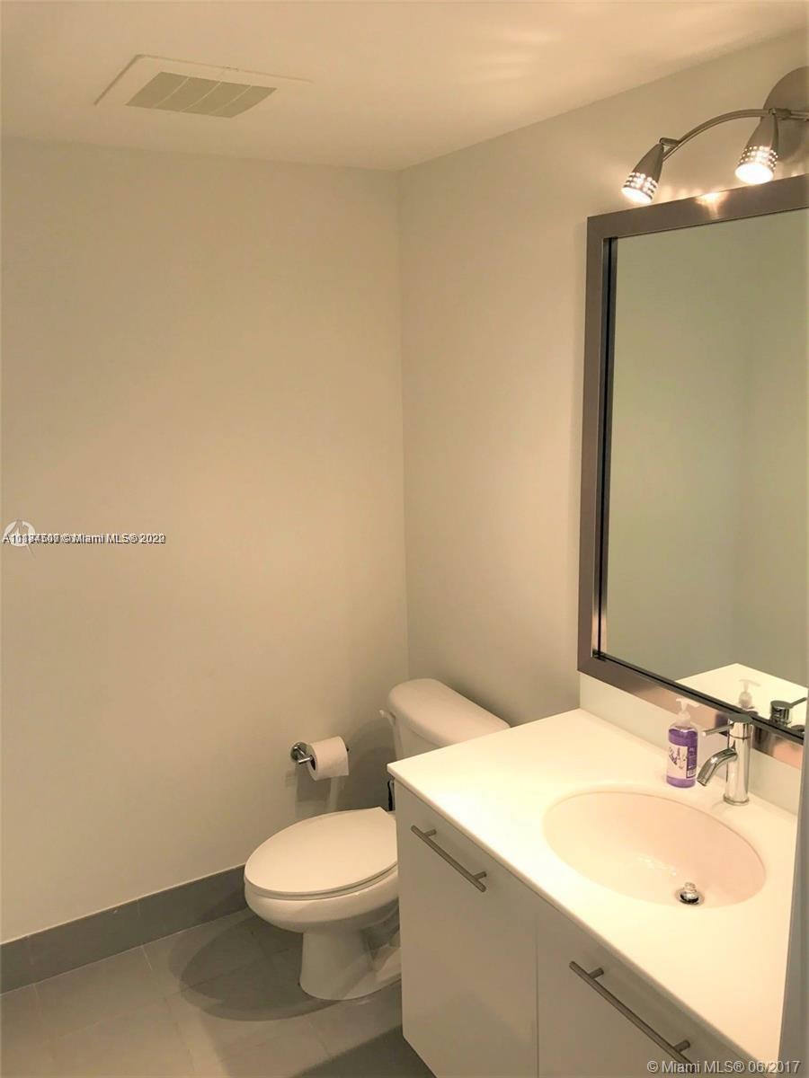 92 Southwest 3rd Street, Unit 2003 Miami, FL 33130 - Photo 21 of 30 a bathroom with a sink a toilet and mirror