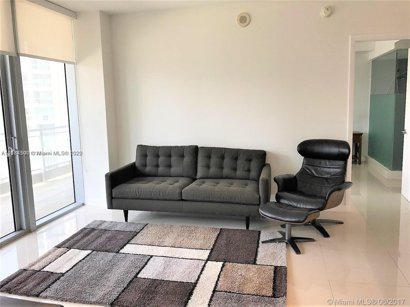 92 Southwest 3rd Street, Unit 2003 Miami, FL 33130 - Photo 10 of 30 a living room with a couch and a rug