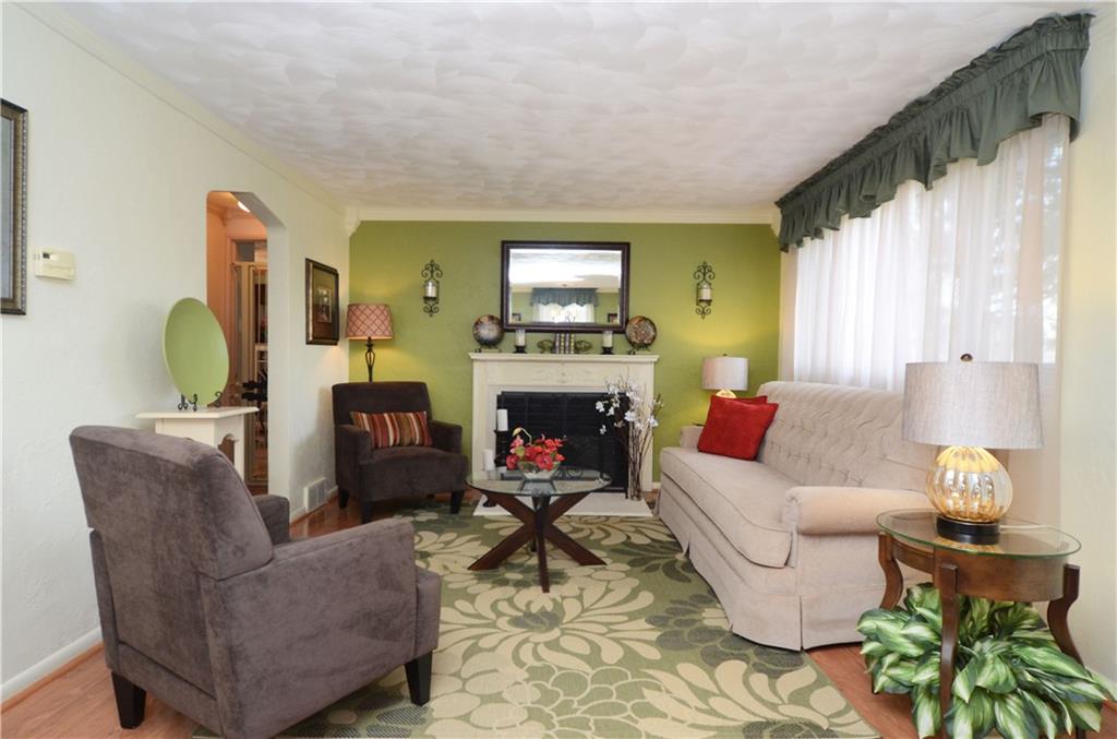 2209 North Forest Grove Road Coraopolis, PA 15108 - Photo 2 of 25 Living Room/Dining Room combination features an electric fireplace, crown molding and laminate flooring. (13x11)
