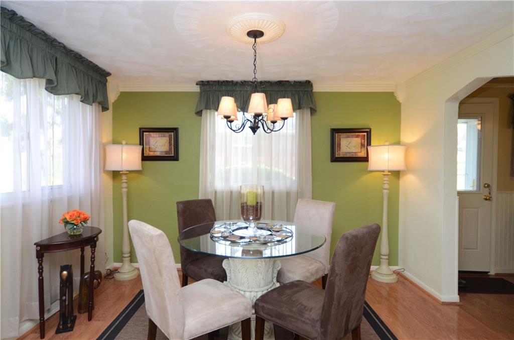 2209 North Forest Grove Road Coraopolis, PA 15108 - Photo 3 of 25 Dining Room/Living Room Combination is bright and sunny. Laminate flooring, crown molding and view of the side door entry.