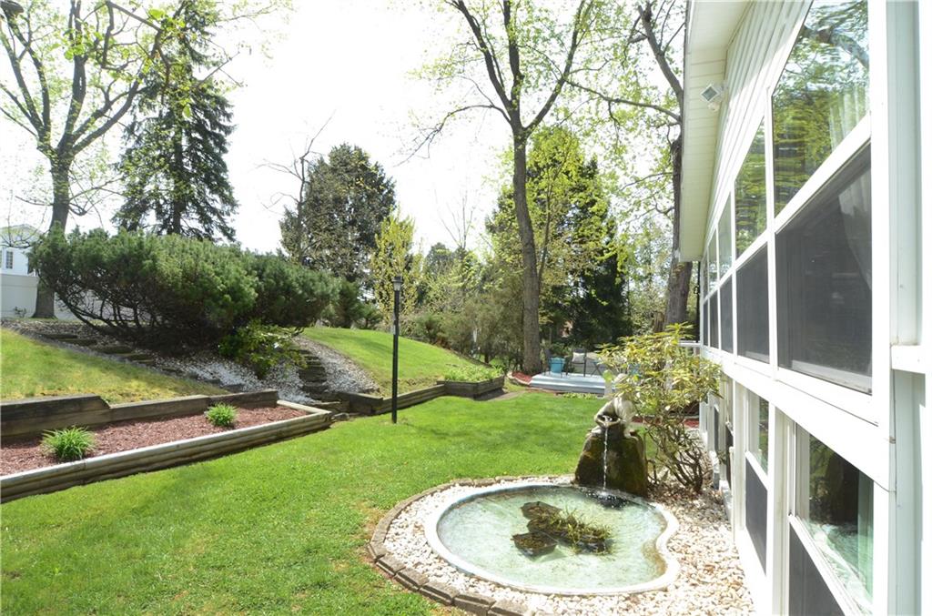 2209 North Forest Grove Road Coraopolis, PA 15108 - Photo 21 of 25 Cross view of the lower tier of the yard. Features a fish pond and a deck in the distance. There is a small shed in this lower section.