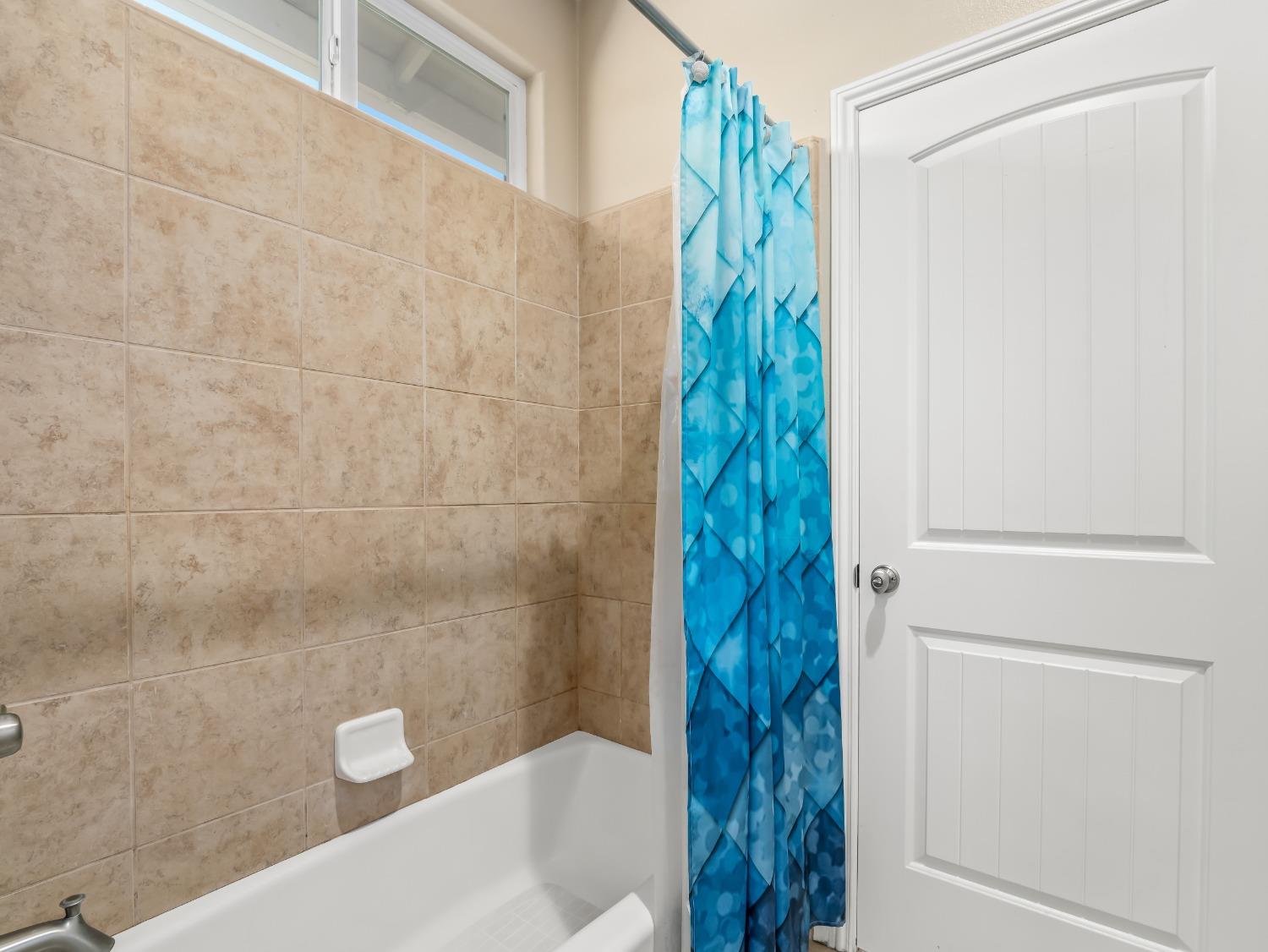 948 Whitmore Avenue Clovis, CA 93619 - Photo 18 of 38 a bathroom with a shower and a tub