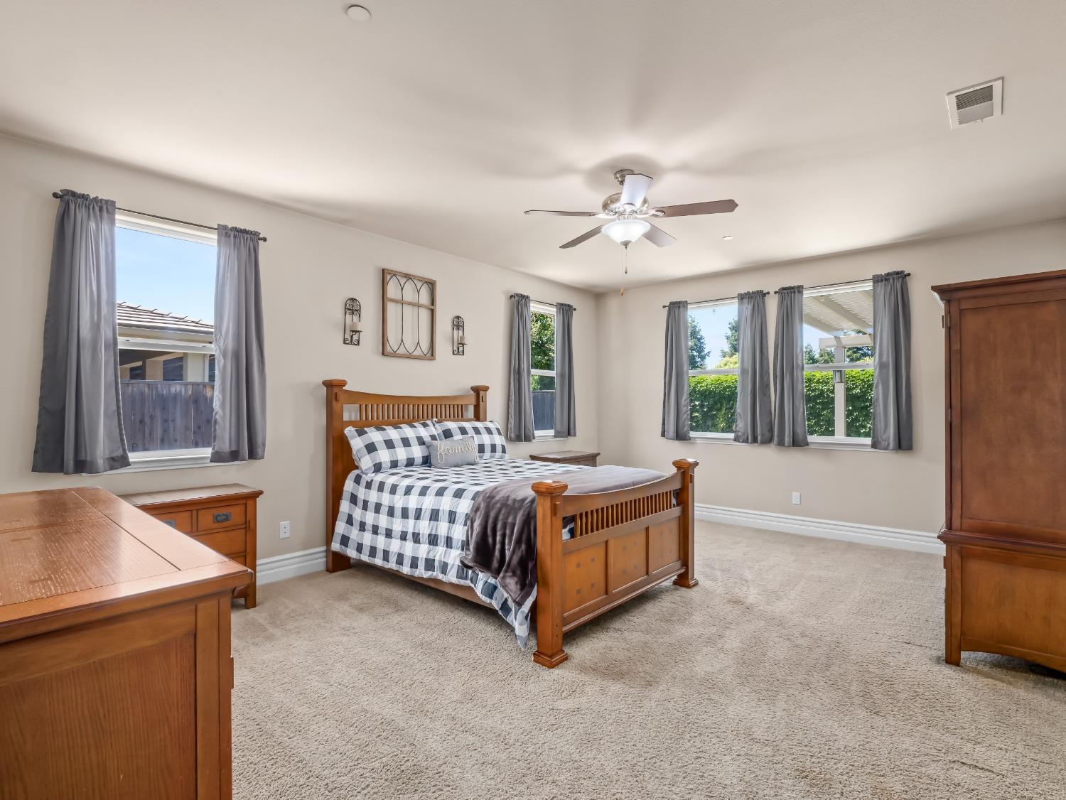 948 Whitmore Avenue Clovis, CA 93619 - Photo 21 of 38 a spacious bedroom with a bed and a chandelier