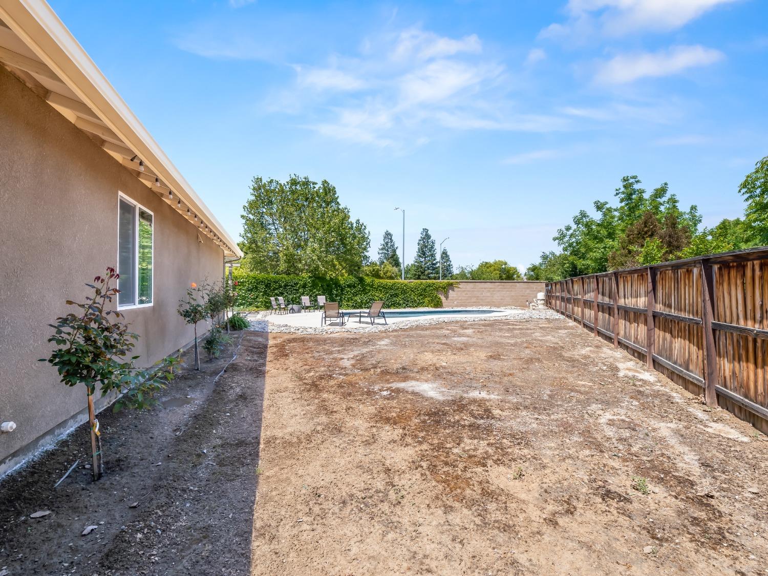948 Whitmore Avenue Clovis, CA 93619 - Photo 31 of 38 a view of backyard with potted plants and wooden fence