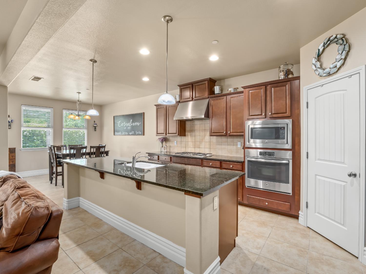 948 Whitmore Avenue Clovis, CA 93619 - Photo 7 of 38 a large kitchen with kitchen island a large counter top space a sink stainless steel appliances and cabinets