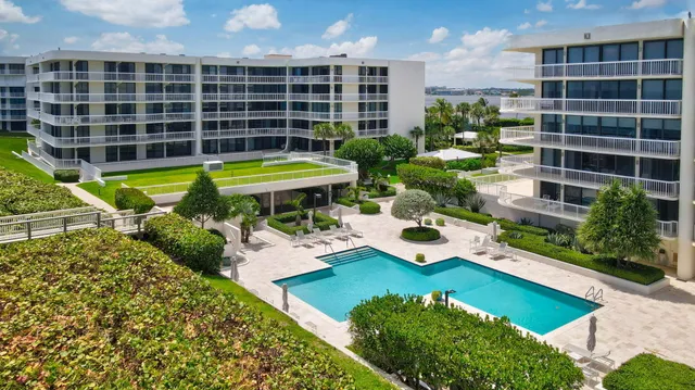 a view of a swimming pool with a patio and a yard