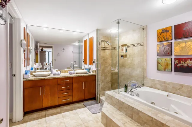 a spacious bathroom with a tub sink shower and mirror