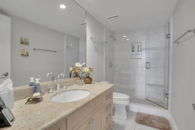 a bathroom with a granite countertop sink a toilet and shower