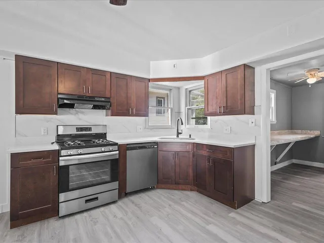 a kitchen with sink stove and cabinets