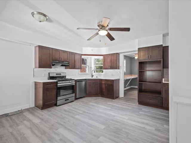 a kitchen with stainless steel appliances kitchen island a refrigerator sink and stove