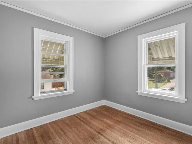 a view of an empty room with wooden floor