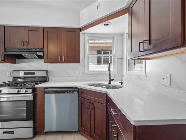 a kitchen with stainless steel appliances granite countertop a sink stove and cabinets