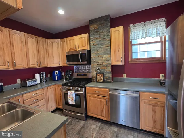 a kitchen with stainless steel appliances granite countertop a sink a stove and cabinets