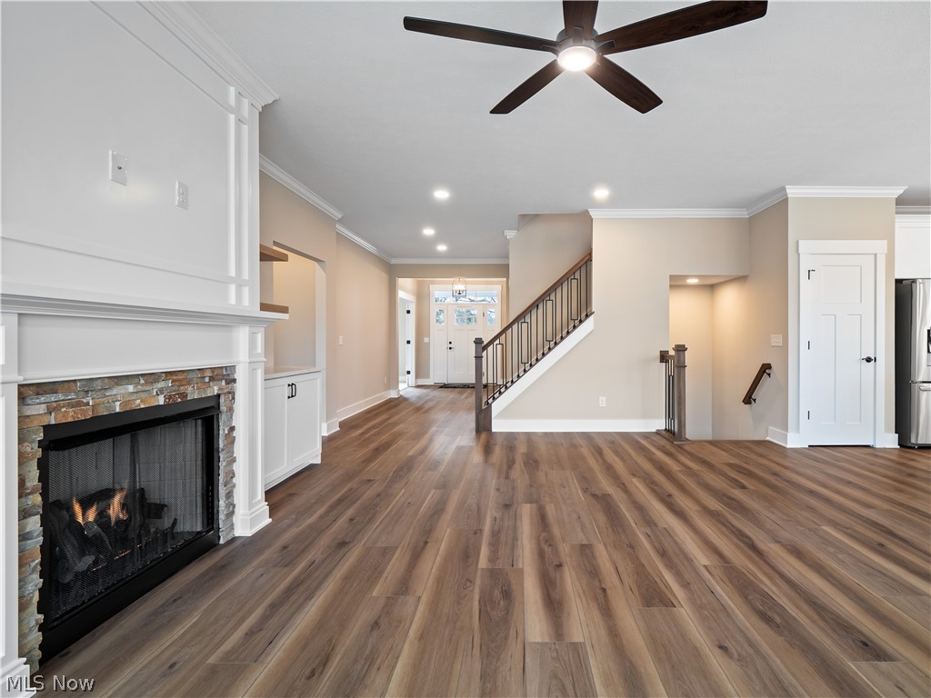 34270 Brookside Lane North Ridgeville, OH 44039 - Photo 11 of 50 Unfurnished living room with ceiling fan, a stone fireplace, crown molding, dark wood-style floors, and recessed lighting