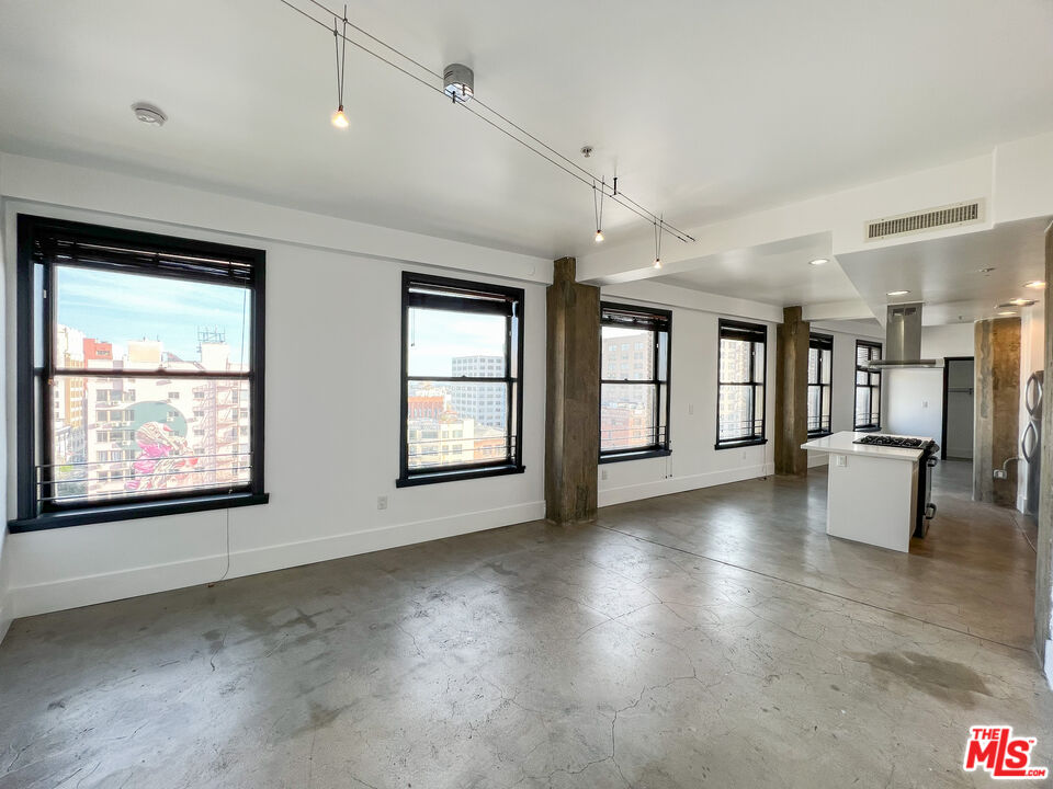 810 South Spring Street, Unit 802 Los Angeles, CA 90014 - Photo 11 of 18 an empty room with fireplace and windows