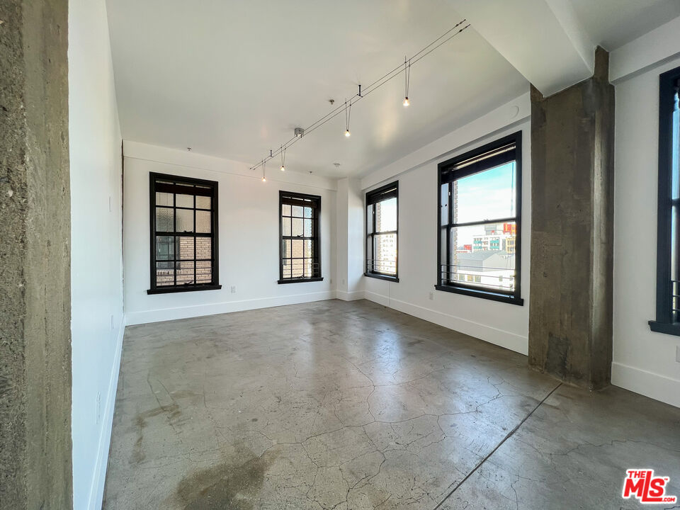 810 South Spring Street, Unit 802 Los Angeles, CA 90014 - Photo 2 of 18 a view of an empty room with windows and chandelier