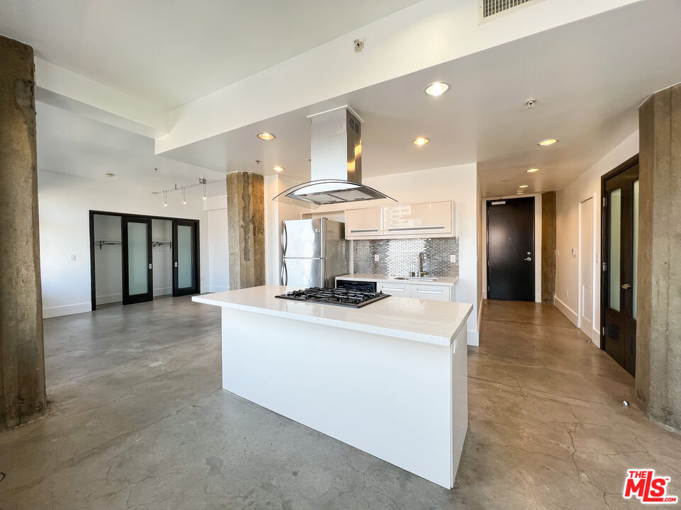810 South Spring Street, Unit 802 Los Angeles, CA 90014 - Photo 4 of 18 a view of kitchen with stainless steel appliances granite countertop refrigerator sink and stove
