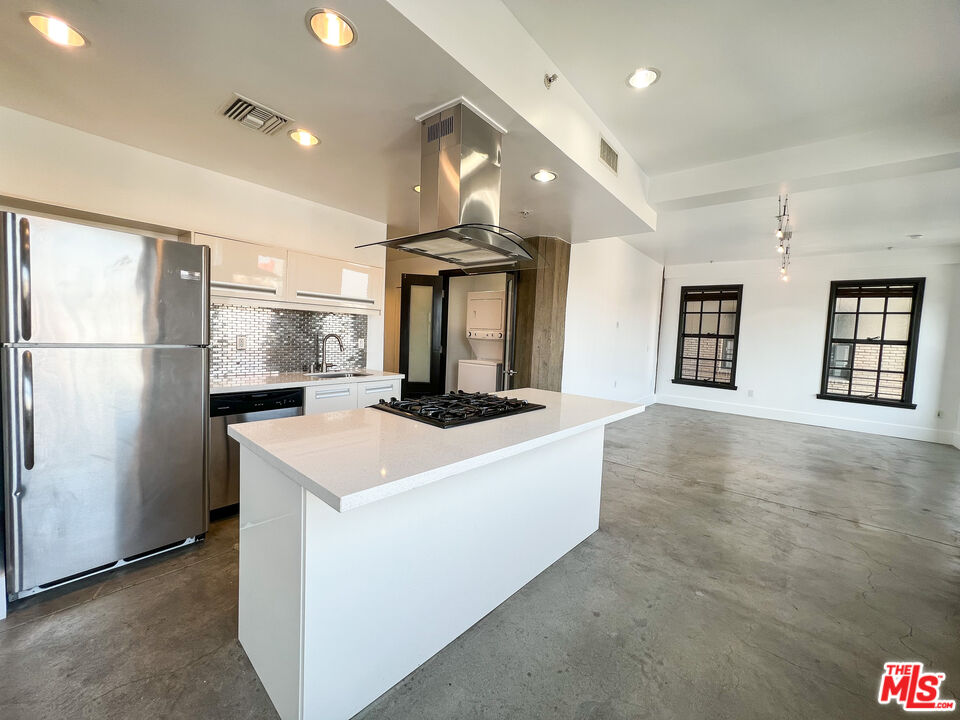 810 South Spring Street, Unit 802 Los Angeles, CA 90014 - Photo 5 of 18 a kitchen with stainless steel appliances granite countertop a sink a stove and a refrigerator