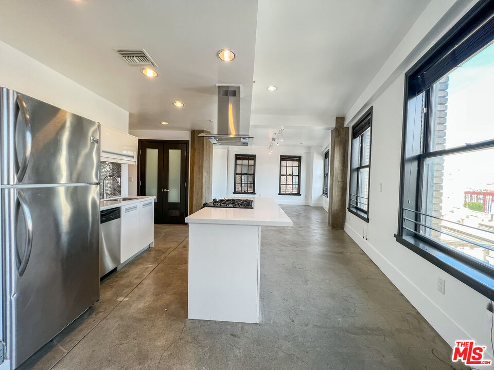 810 South Spring Street, Unit 802 Los Angeles, CA 90014 - Photo 10 of 18 a kitchen with stainless steel appliances granite countertop a refrigerator a oven a sink and a large window