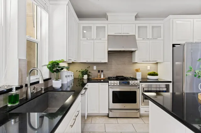 a kitchen with stainless steel appliances granite countertop a sink stove and refrigerator