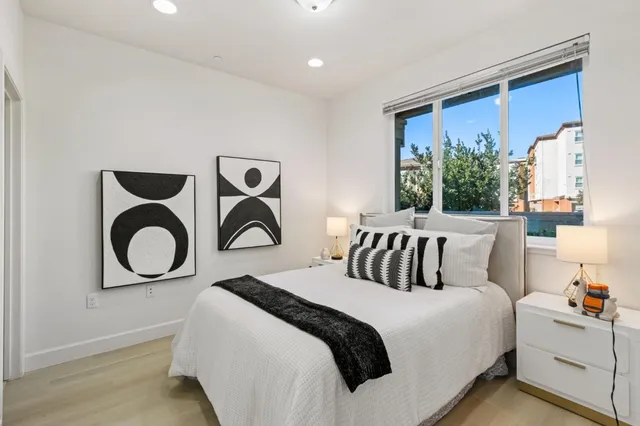 a bedroom with a bed and a large window