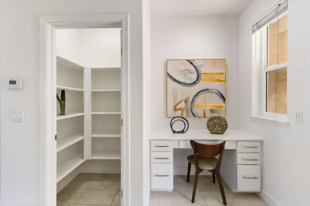 a view of a room that has a table and a chair in it