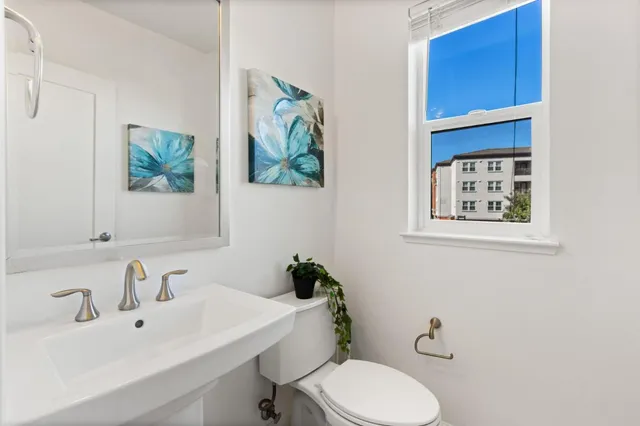 a bathroom with a sink mirror and toilet