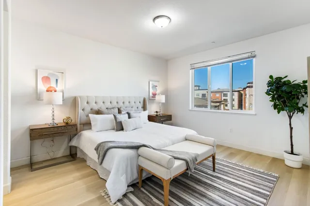 a bedroom with a bed and a potted plant