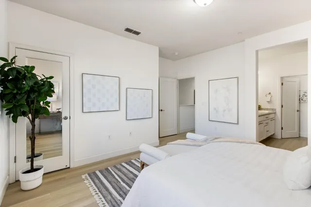 a bedroom with a bed and a potted plant